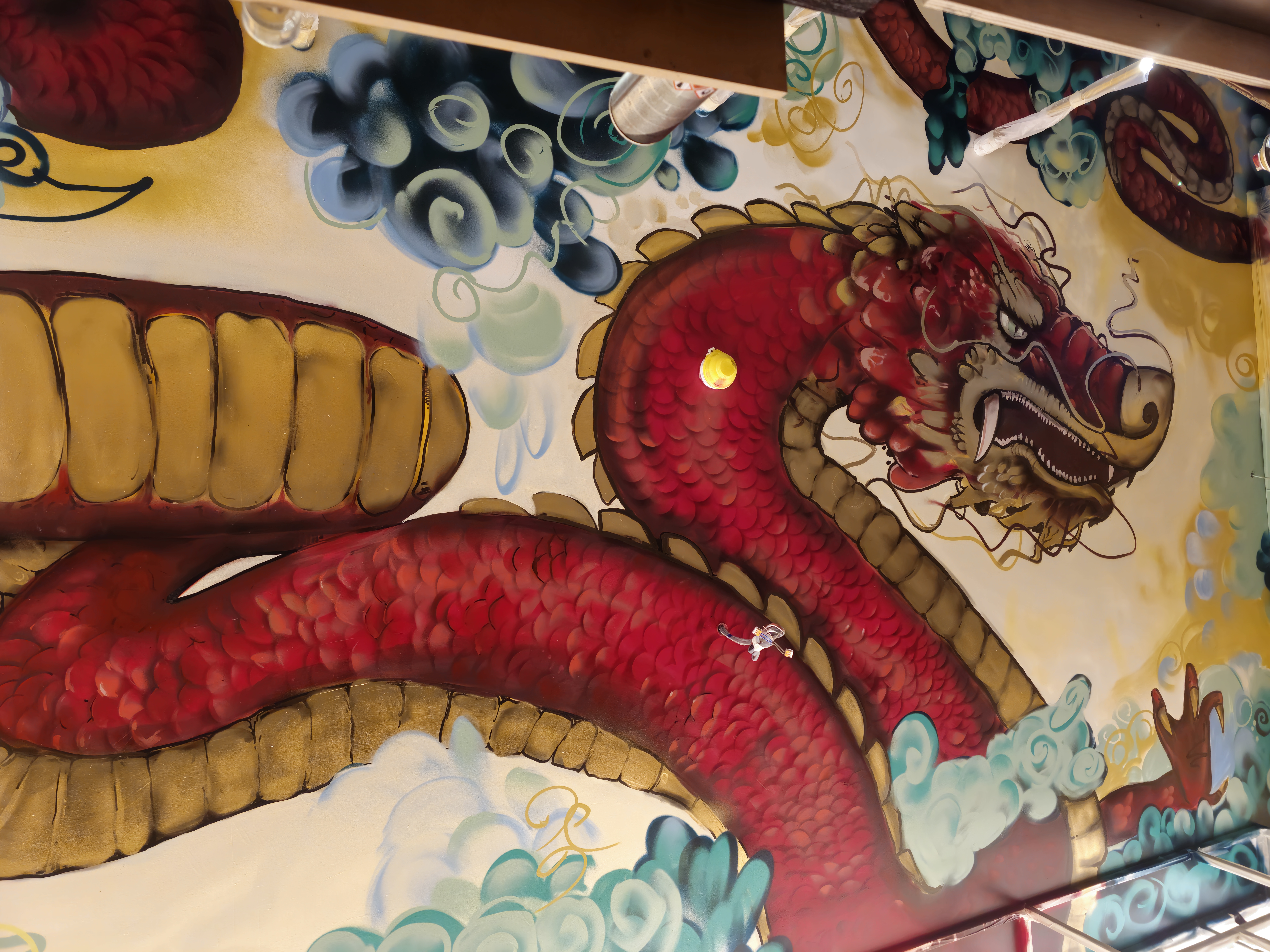 Red and gold dragon mural painted across the ceiling of a restaurant in Ilford, east London