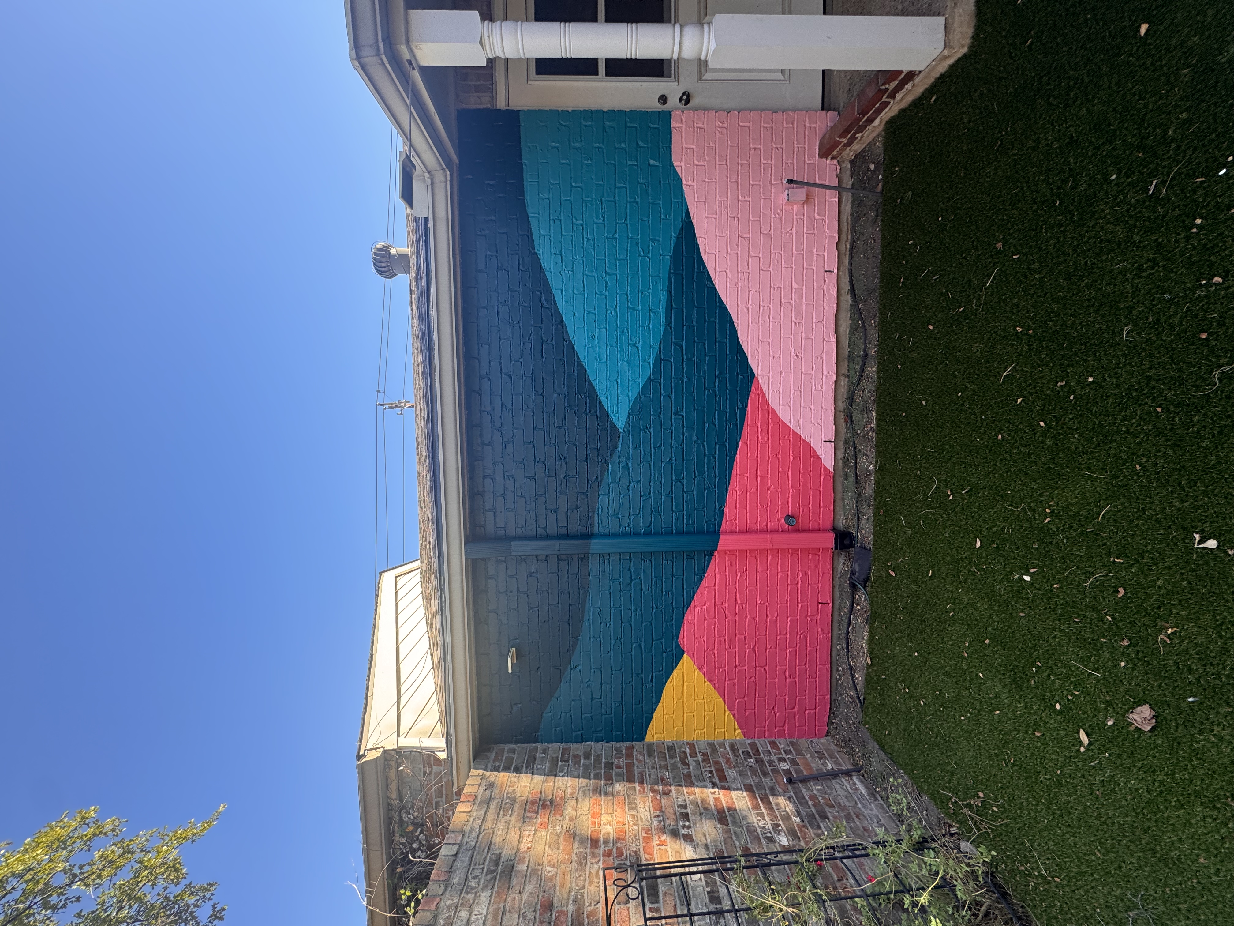 Desert scene mural on a backyard brick wall in Austin