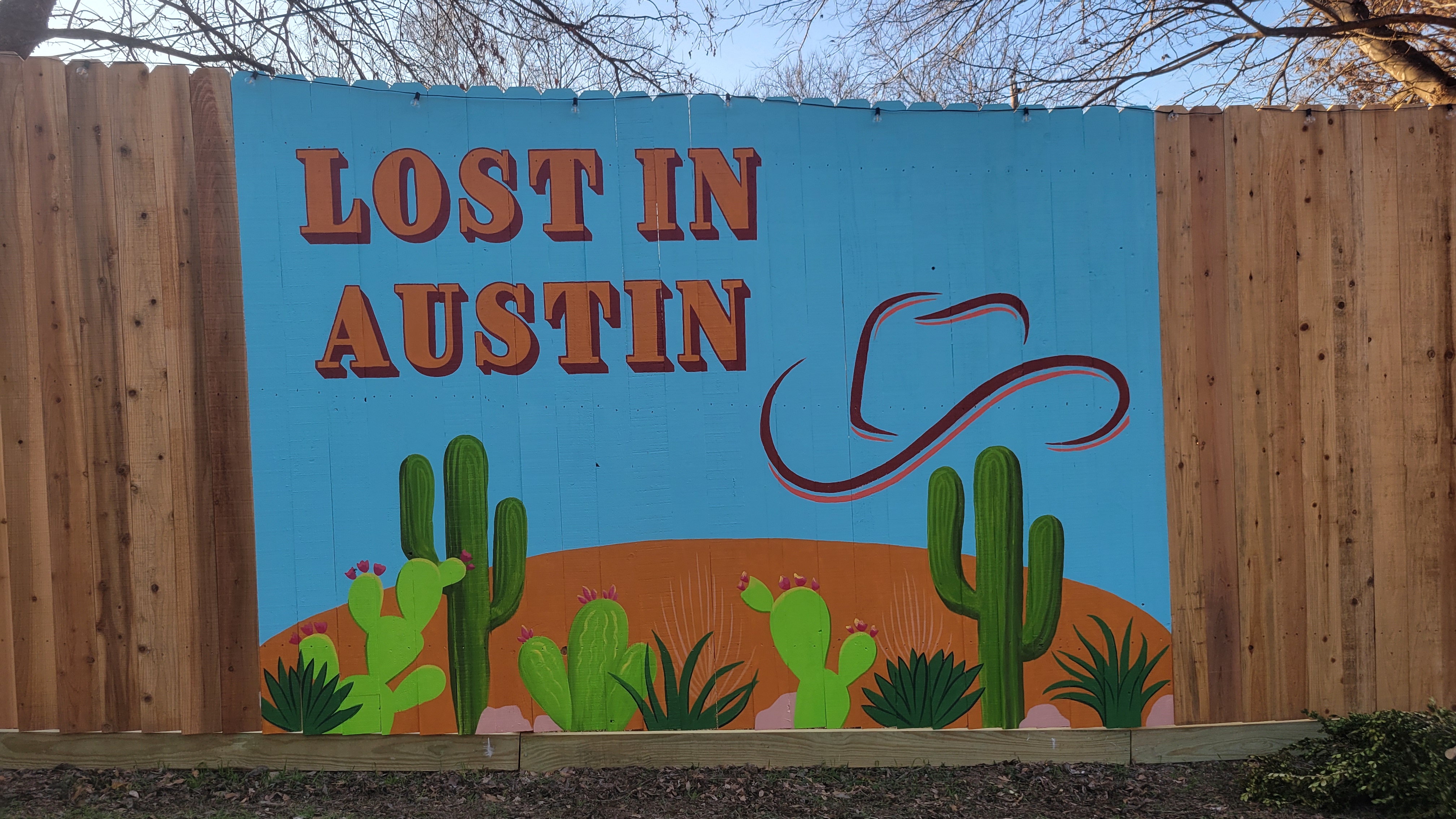 Lost in Austin sunset fence mural with cowgirl on horseback