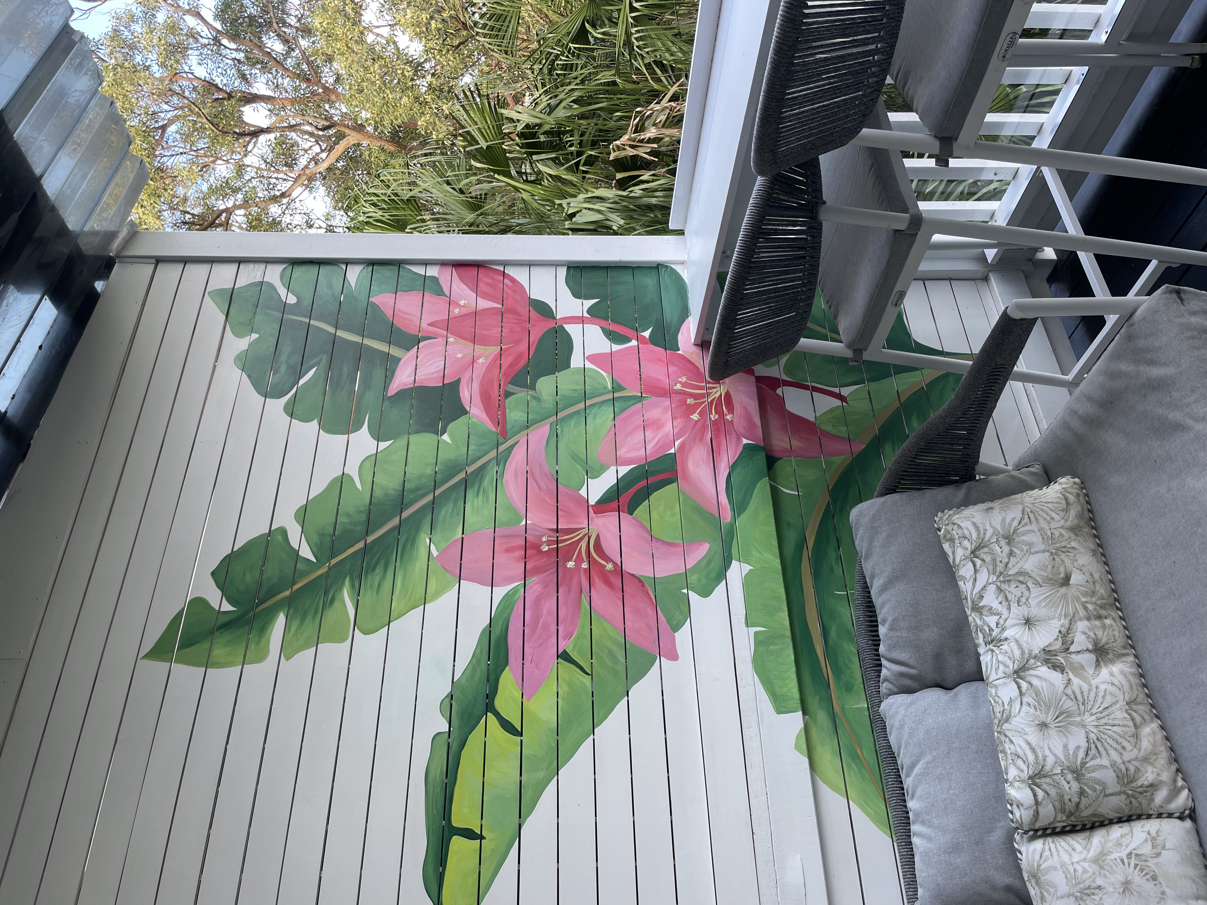 Pink lily mural painted on a weatherboard deck wall in Coogee, Sydney