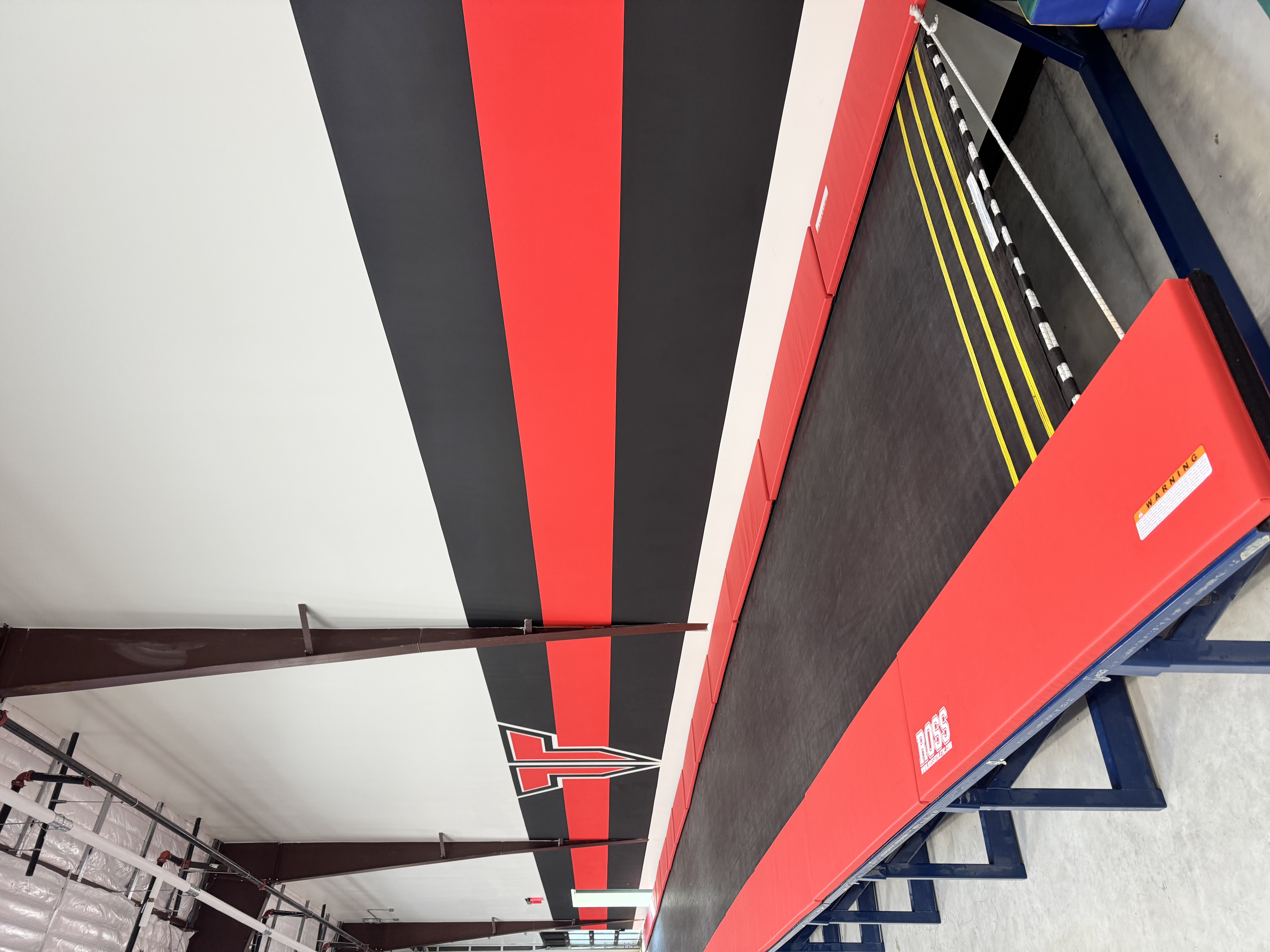 Black and red logo mural painted in an Austin cheerleading gym