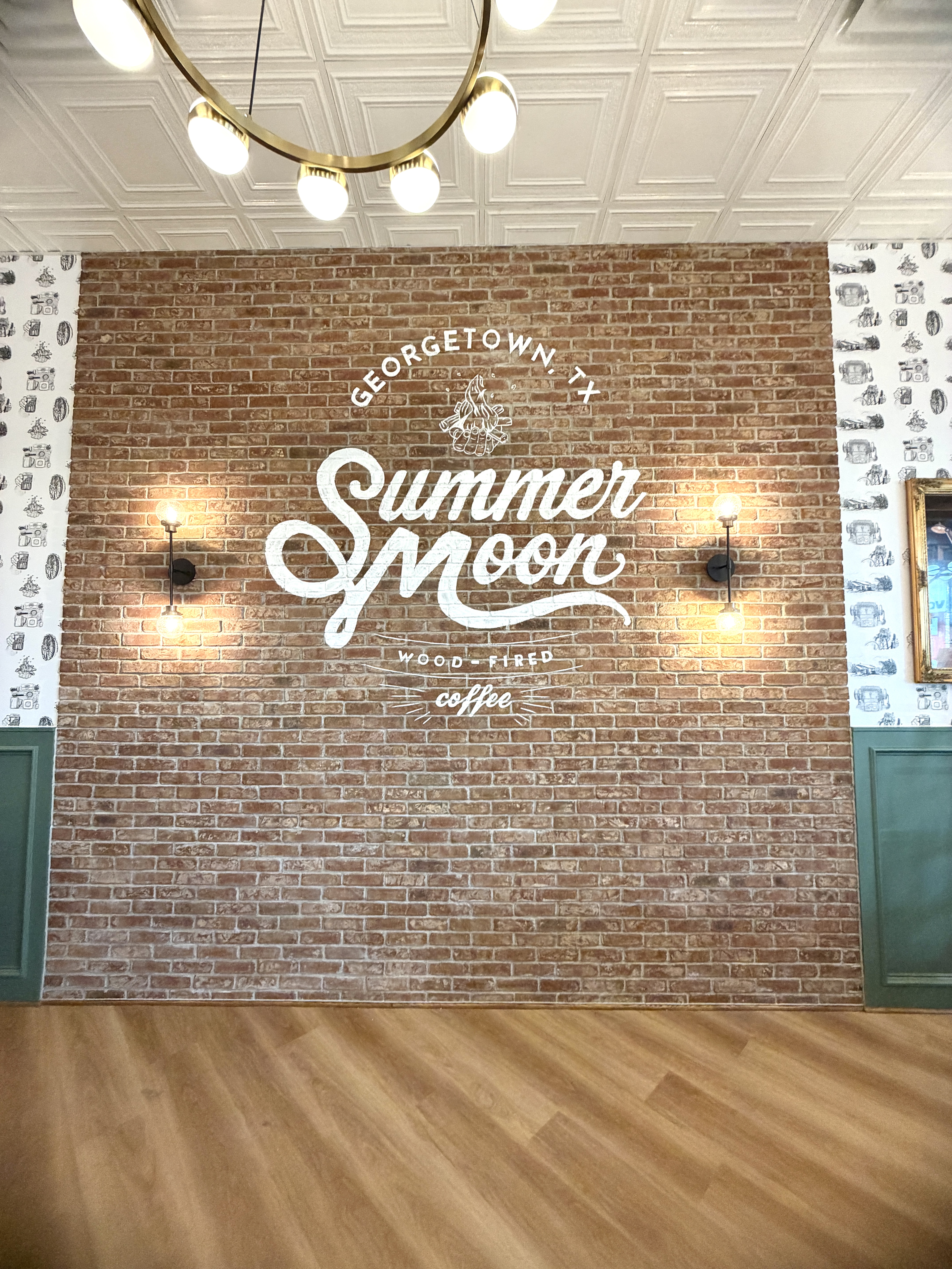Hand-painted Summer Moon Coffee logo mural on exposed brick in Georgetown near Austin